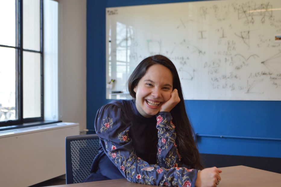 Ananda Santos Figueiredo sitting at a table with her face resting on her hand.